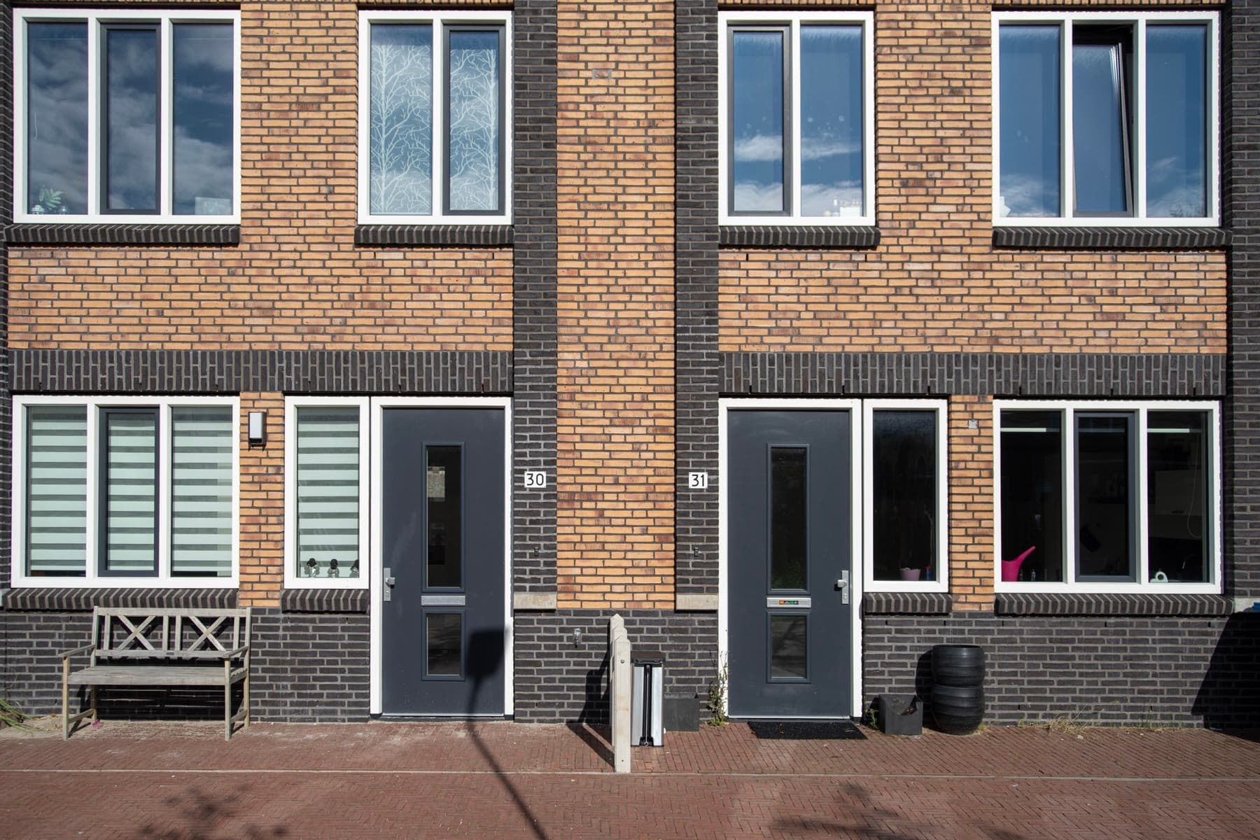 Nederlandse rijtjeshuizen met bakstenen gevel aan een woonstraat